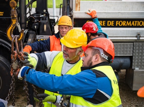 friderici-special-our-activities-security Techniciens manipulant des chaînes de levage pour manutention industrielle